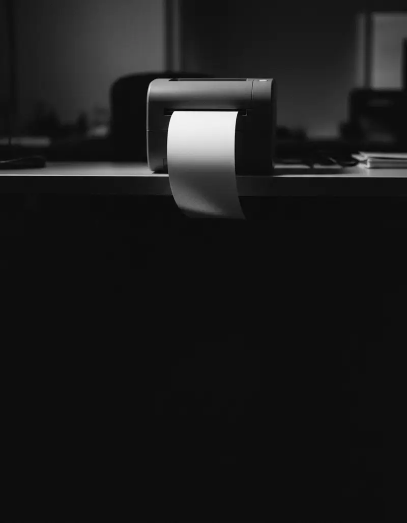 Impressora pequena num escritório escuro